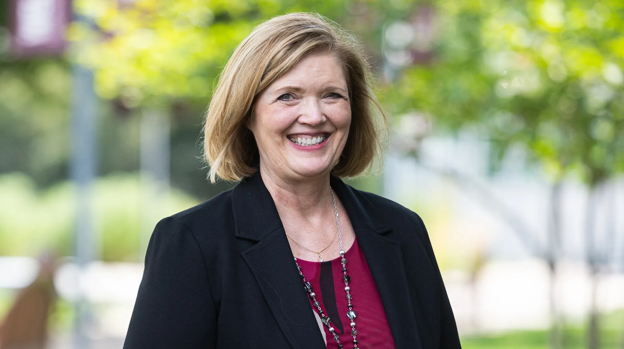 Woman smiling outdoors in professional attire
