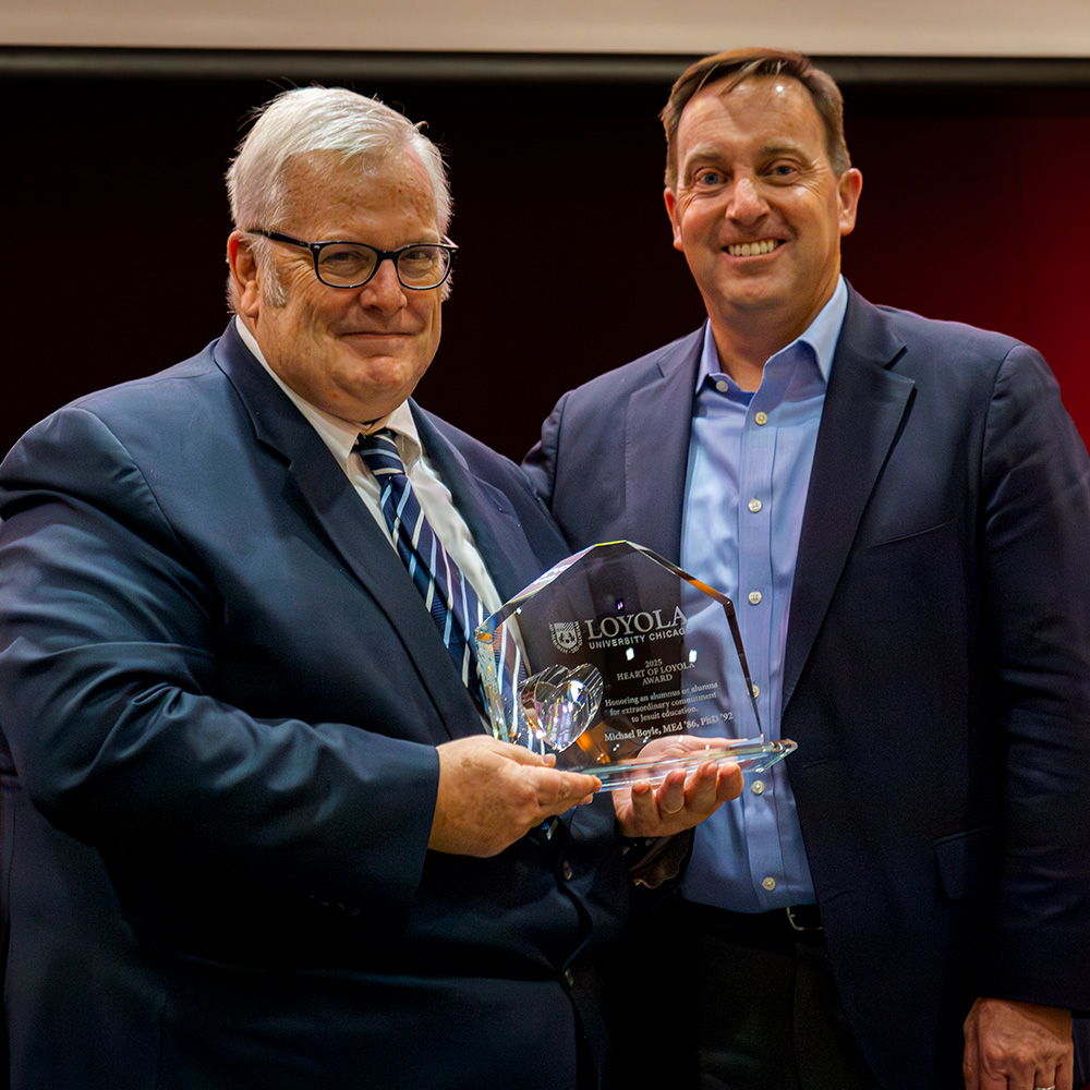Michael Boyle (Med 86, PhD 92) accepts the 2025 Heart of Loyola Award from Dr Reed.
