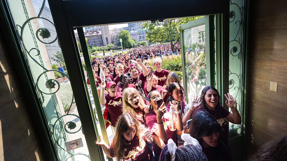 Incoming students walk through the Cudahy Library doors to celebrate the start of the academic year.