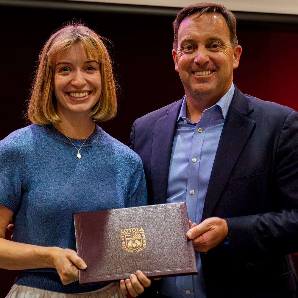 Emily Prust (BA 18) accepts the 2025 Rambler on the Rise Award from Dr Reed.