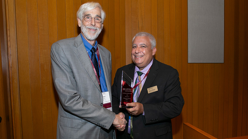 Bruce Zuraw, MD 75, receives the 2025 Excellence in Education Award from Dean Sam J Marzo.