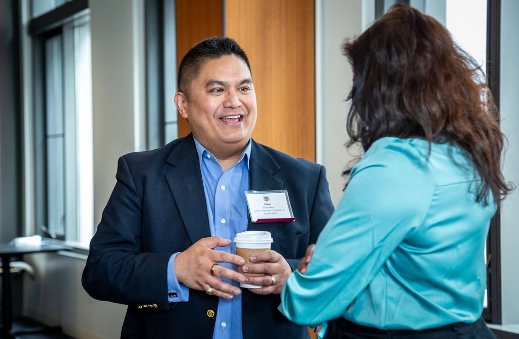 An alumnus chats over coffee with a student at a LoyolaLinked event.