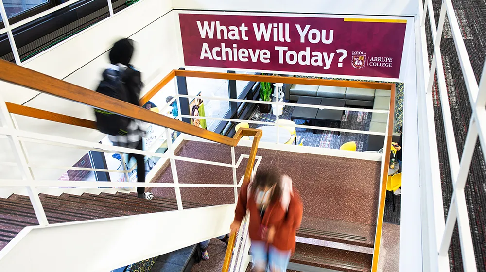 Arrupe students walking down stairs in Maguire Hall Arrupe students walking down stairs in Maguire Hall