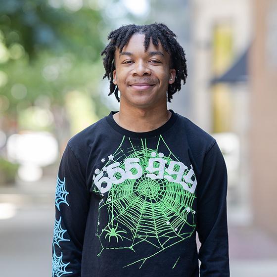 Portrait of a smiling student wearing a black graphic sweatshirt on Loyola University Chicago’s campus. Portrait of a smiling student wearing a black graphic sweatshirt on Loyola University Chicago’s campus.
