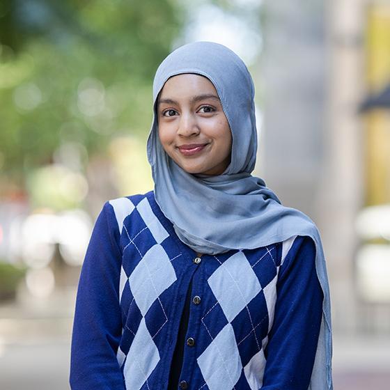 Portrait of a smiling student wearing a light blue hijab and blue argyle sweater on Loyola University Chicago’s campus. Portrait of a smiling student wearing a light blue hijab and blue argyle sweater on Loyola University Chicago’s campus.