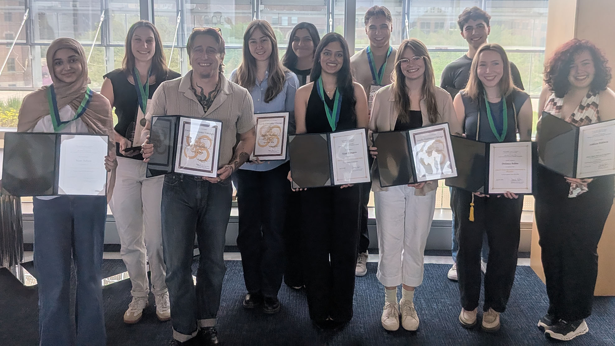 Students holding awards and certificates in a group photo