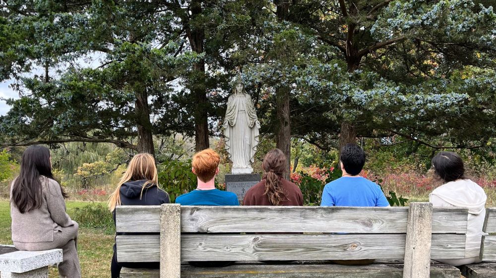 6 students holding hands in prayer 