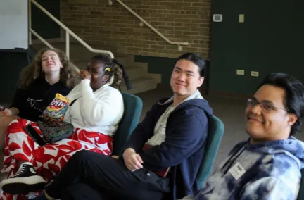 John smiling at the camera with other students around him.