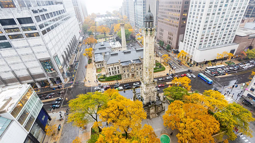 Aerial view of Chicago’s Water Tower and downtown skyline near Loyola’s Water Tower Campus in autumn