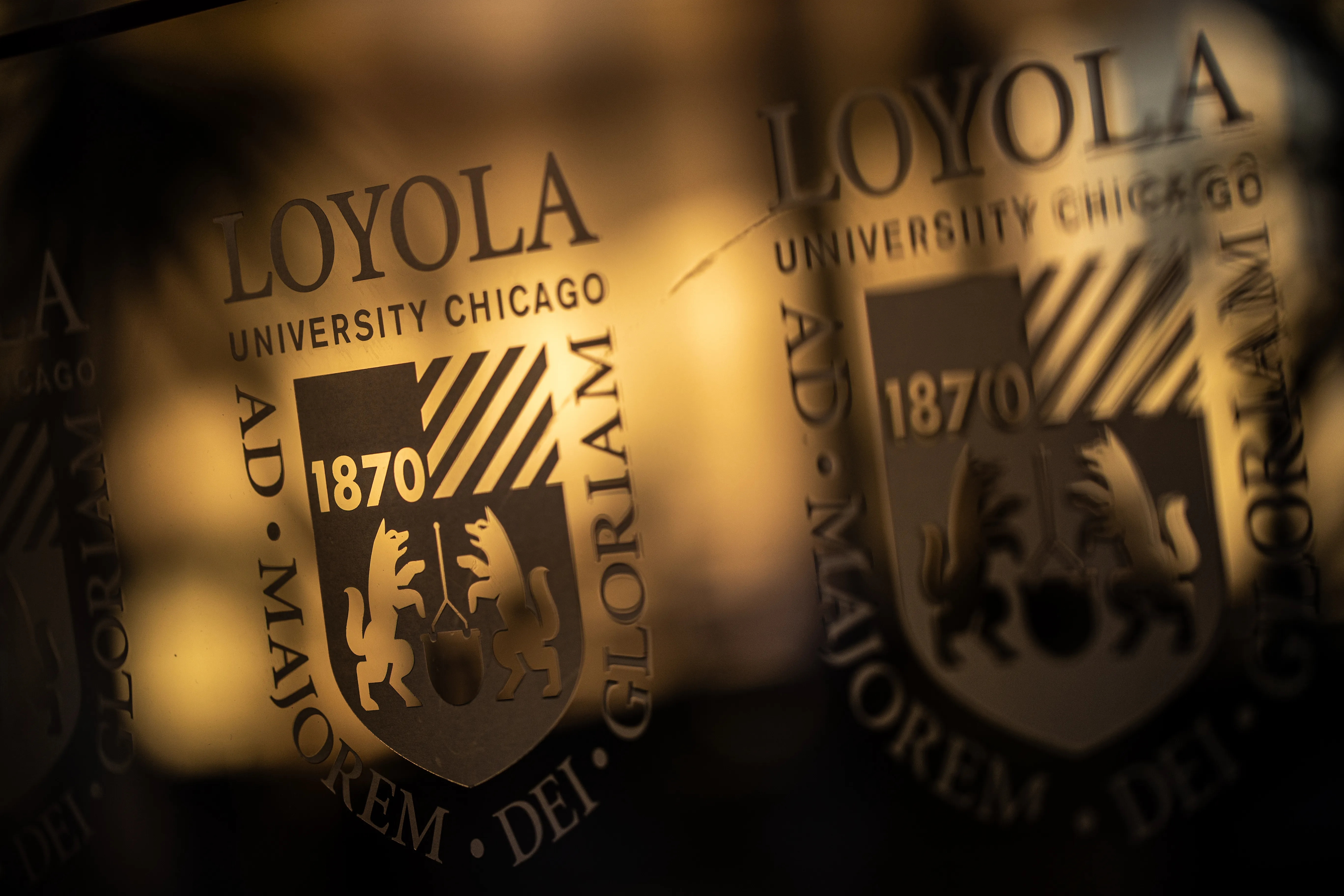 Loyola University Chicago seal with the university crest and founding year 1870, shown in a close-up reflection.