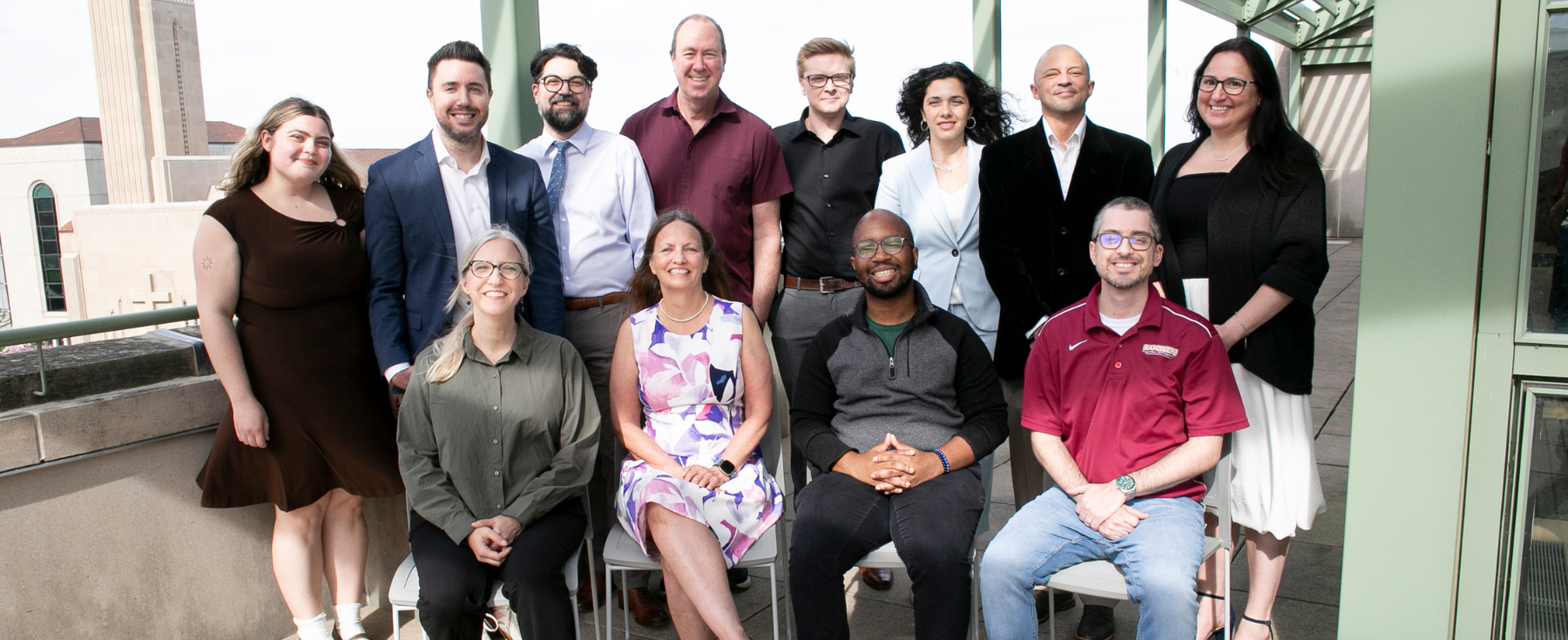 CJC Faculty and Staff standing together on the Palm Court balcony