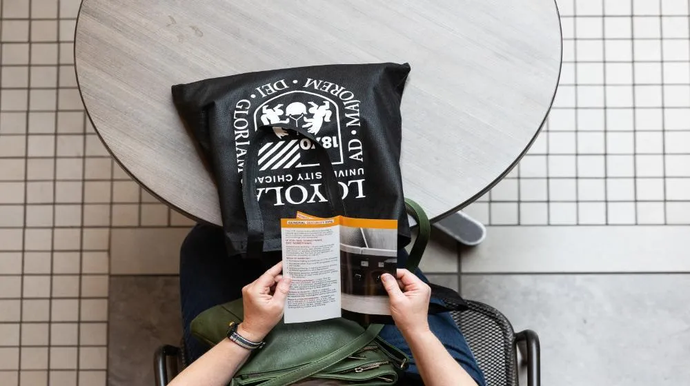 Overhead image of a person holding a brochure via Loyola University Chicago's financial student resources. Overhead image of a person holding a brochure via Loyola University Chicago's financial student resources.