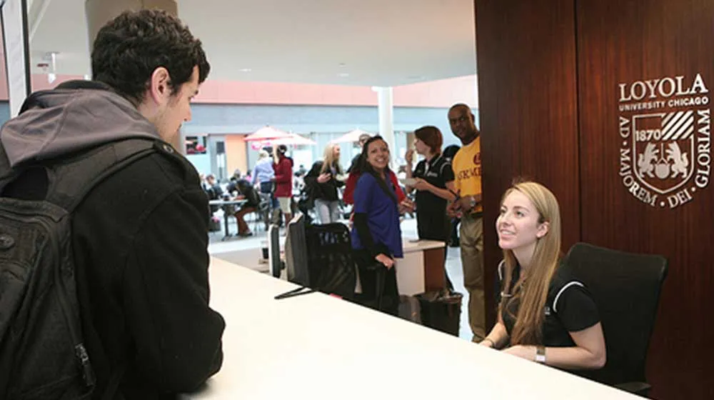 Student workers offer assistance at Damen Student Center info desk Student workers offer assistance at Damen Student Center info desk