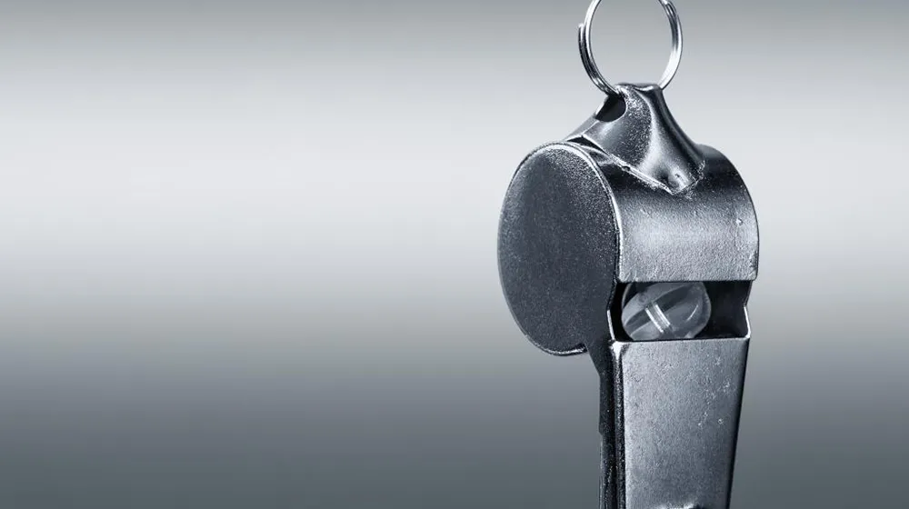 Close shot of a silver sports whistle hanging facedown, symbolizing the Loyola University Chicago Ethics hotline.