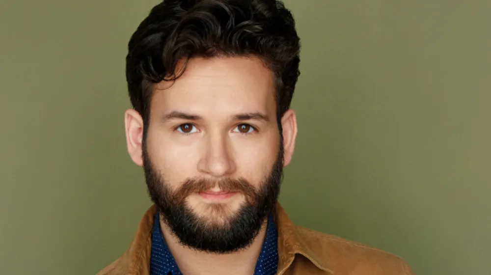 John Drea in a portrait studio standing in front of a backdrop.