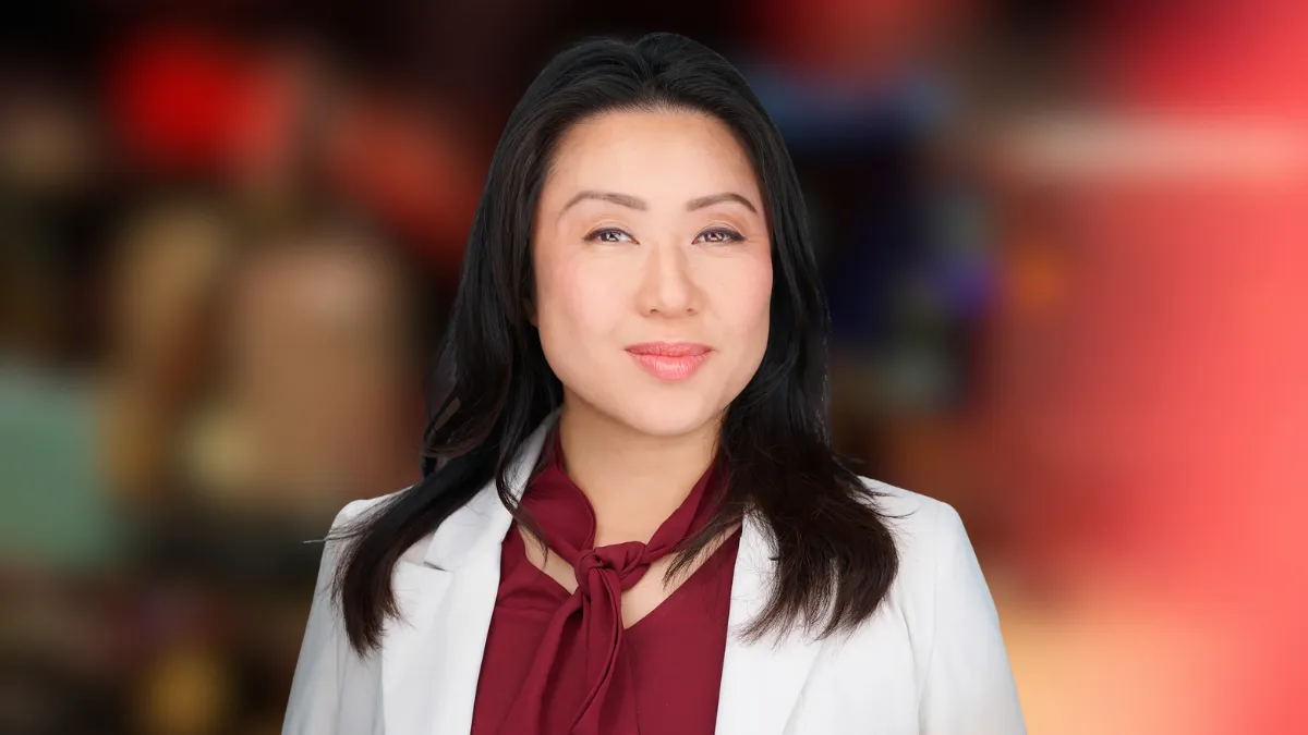 Dr. Chee smiles in front of a digital background
