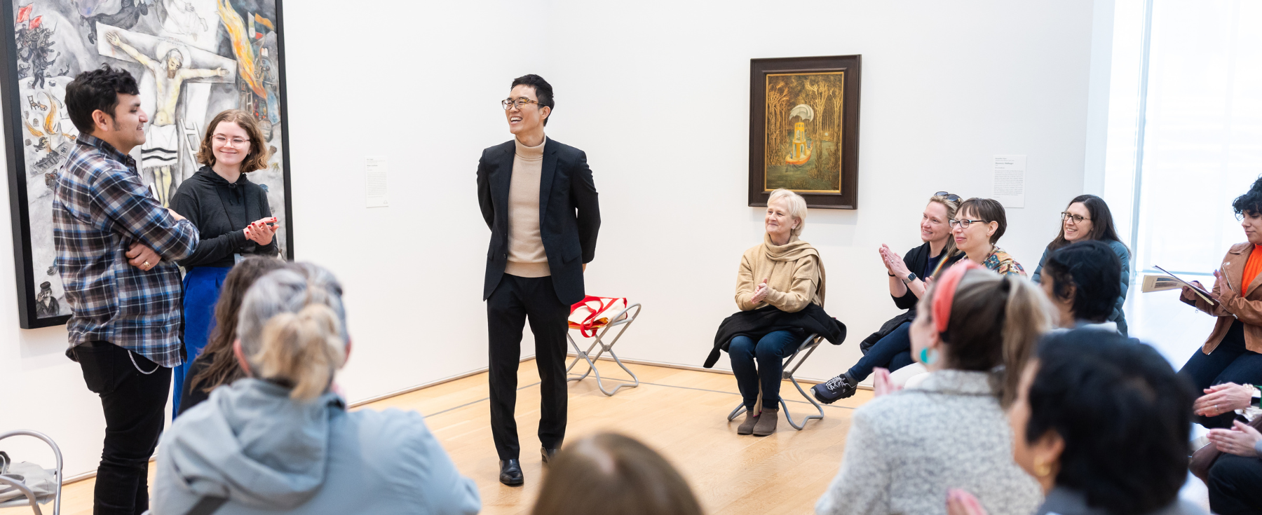 Maestro sonriendo mientras interactúa con estudiantes.