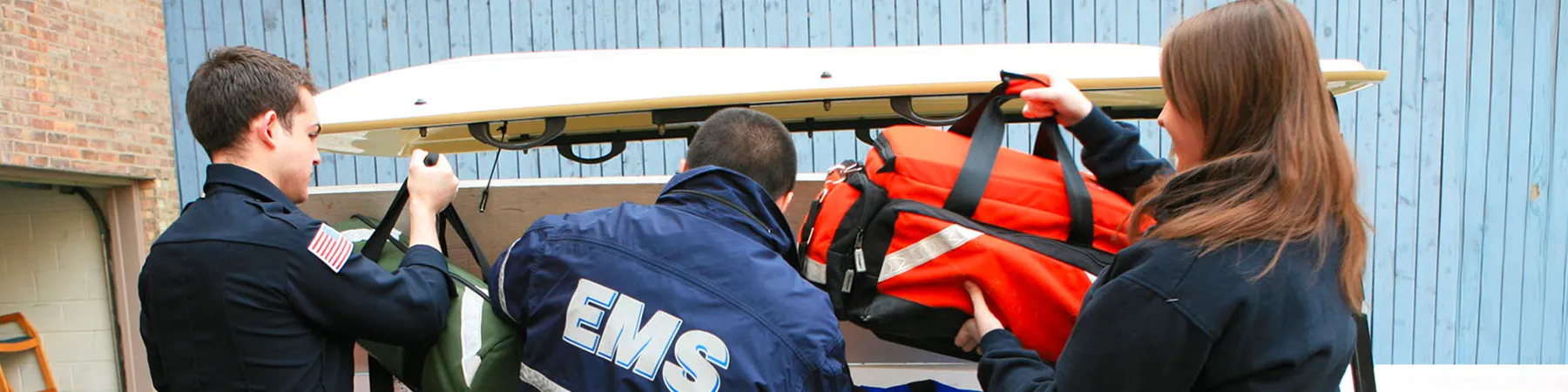 EMS professionals are loading up the trunk of a vehicle