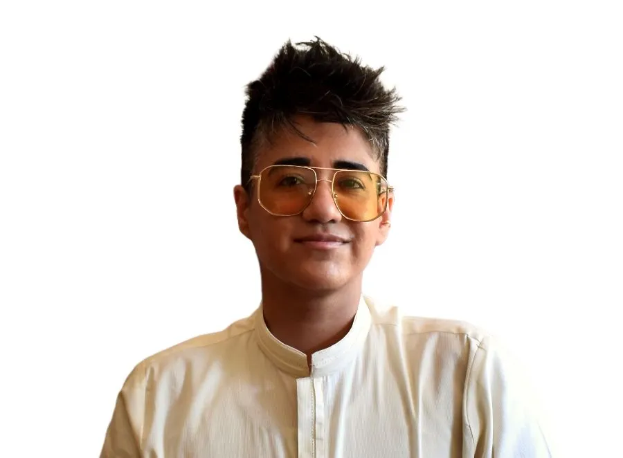 Person with short hair and glasses against a plain background.