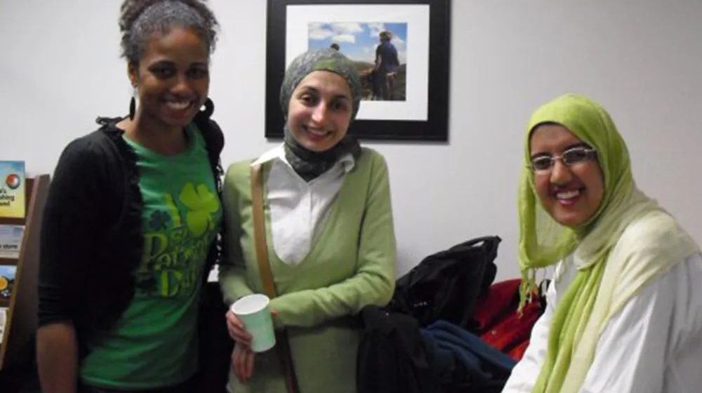 Multiple ESL students wearing shades of green pose for a group photo