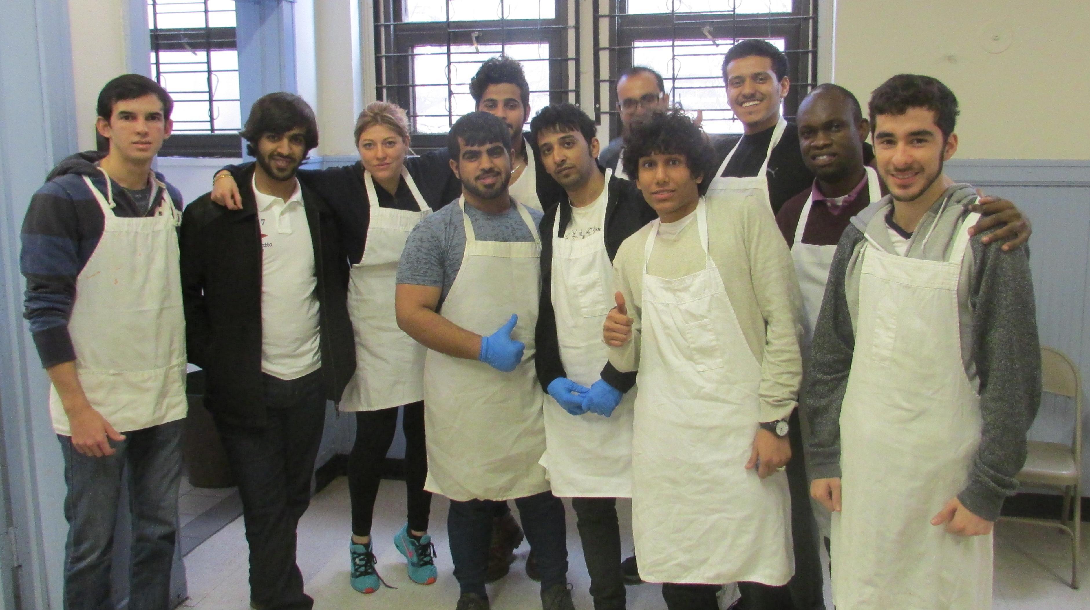 A group of ten students from Loyola University’s English Language Learning Program (ELLP) pose together inside a bright community café.