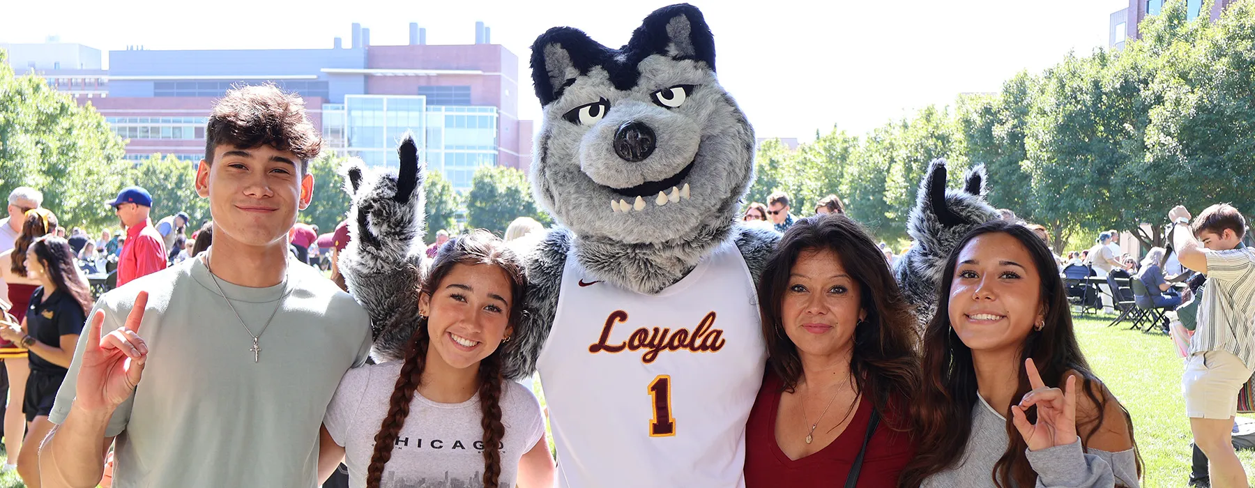 A family smiles with LU Wolf at Family Weekend.
