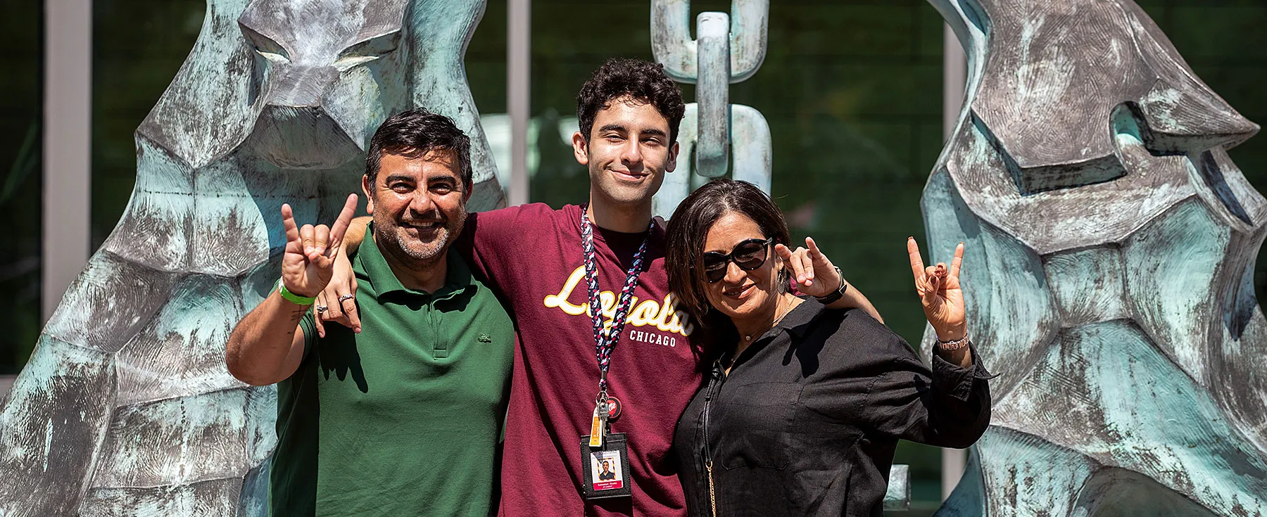 A family stands in front of the Los Lobos statue.