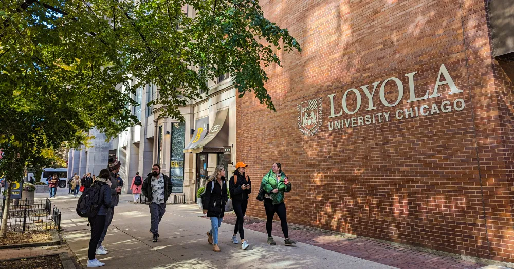 Students walk past the Arrupe College building on the Water Tower Campus.