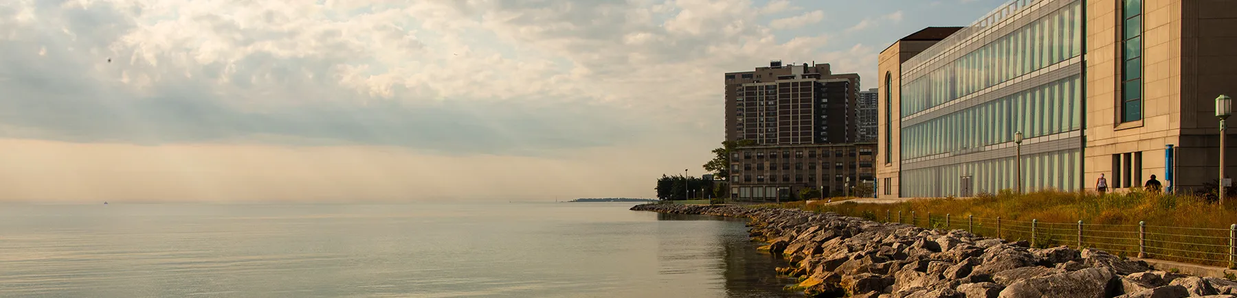 Fachada de la Biblioteca Information Commons desde la costa rocosa del lago Michigan.