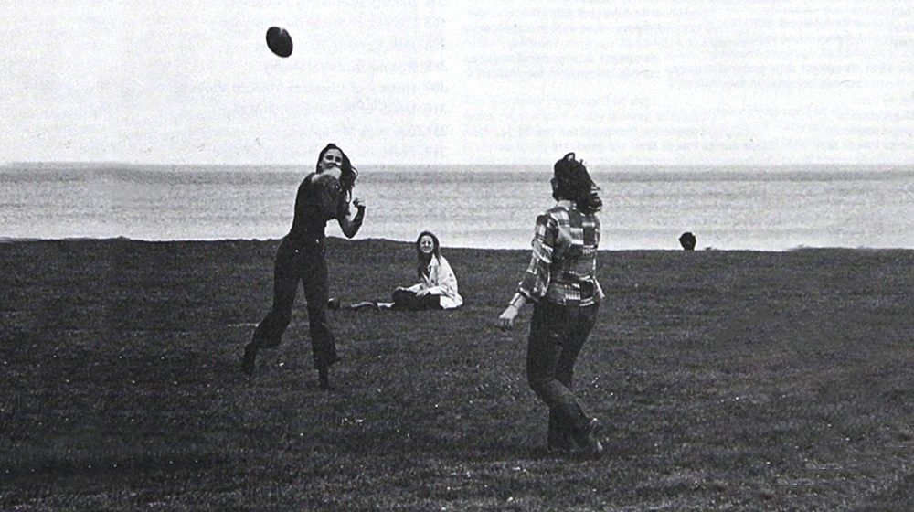 Graduate Students at Loyola play footbal on the beach near campus. 