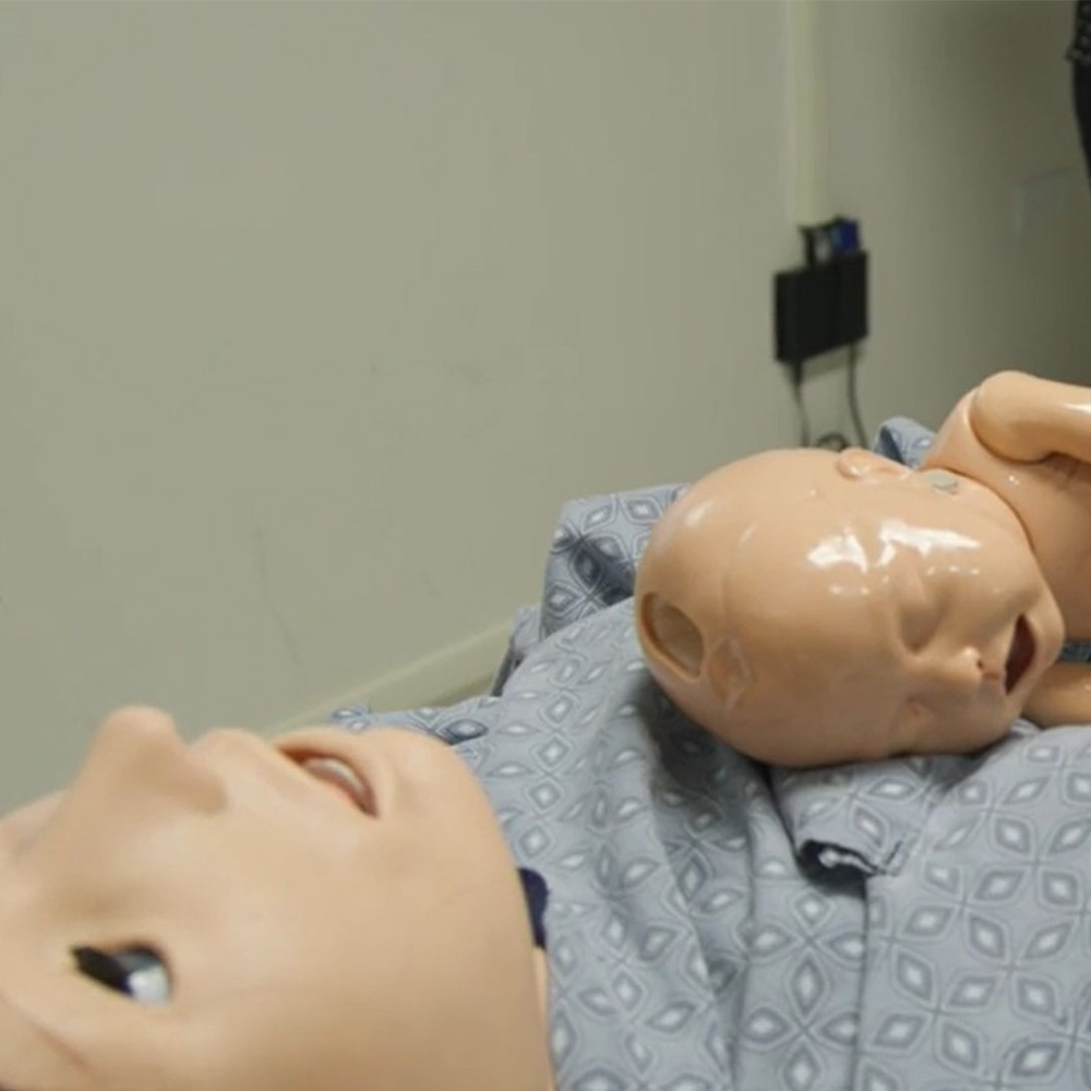 A birthing mother manikin with newborn used for medical training A birthing mother manikin with newborn used for medical training
