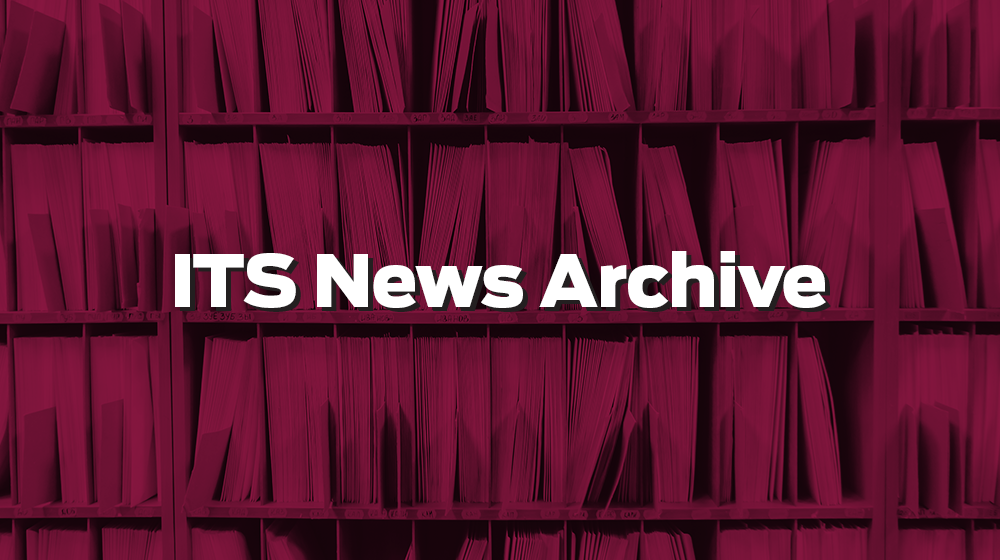 A wall of filing folders and documents stored in an archive in a maroon tint with the text 