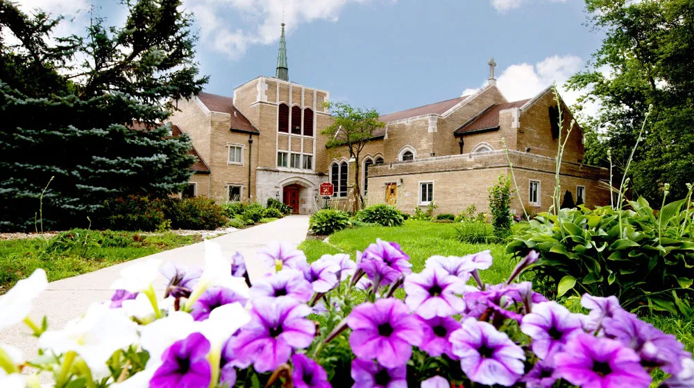 Loyola's Retreat and Ecology Campus Located in Woodstock, Illinois with colorful flowers visible in the foreground.