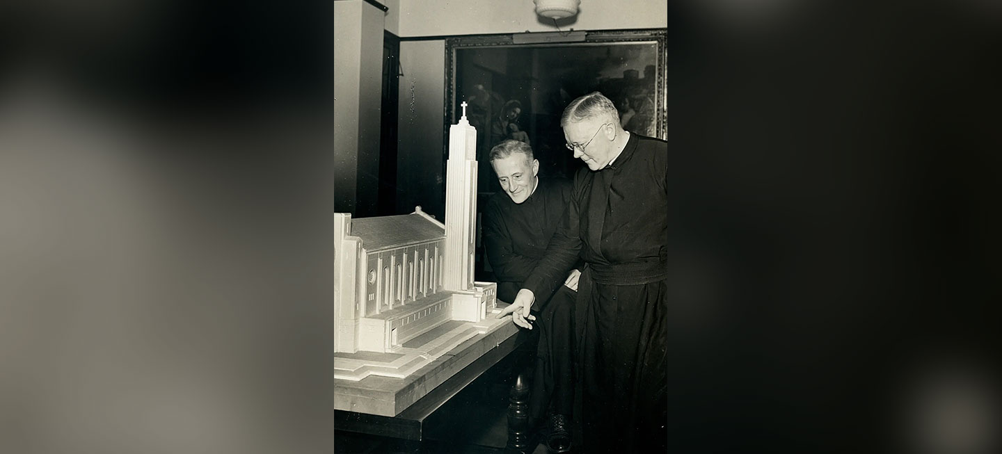 Frs. James J. Mertz, S.J., and Samuel K. Wilson, S.J. overlooking a model of Madonna della Strada Chapel. 