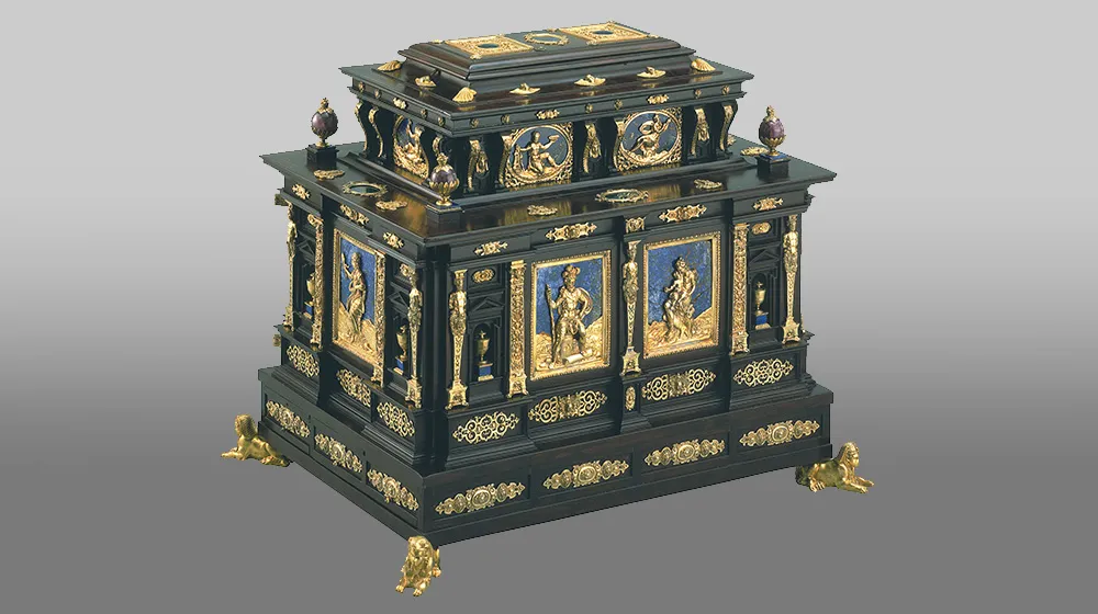 An ornate black and gold chest with navy blue accents and carved, gold feet. from the LUMA museum collection of art. An ornate black and gold chest with navy blue accents and carved, gold feet. from the LUMA museum collection of art.