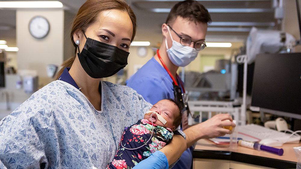 Assistant Professor Thao Griffith holds a newborn Assistant Professor Thao Griffith holds a newborn