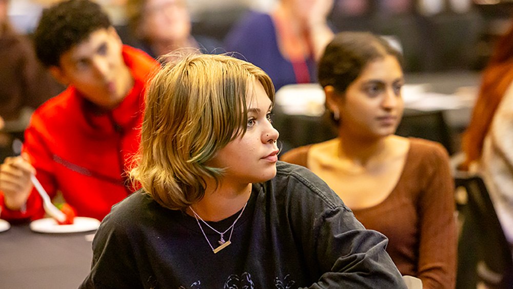 Three students in a classroom setting are listening intently Three students in a classroom setting are listening intently