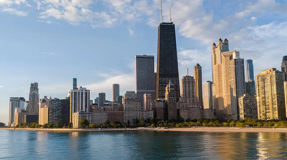 A lake view of the northern loop of Chicago on a day with a bright blue sky. The city building reflect in the Lake Michigan Oak Street Beach water. A lake view of the northern loop of Chicago on a day with a bright blue sky. The city building reflect in the Lake Michigan Oak Street Beach water.