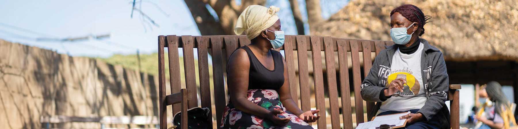 Friendship Bench Ambuya Utano (Community Grandmother) having a problem-solving therapy session on the Friendship Bench in Harare, Zimbabwe. by Costa Juta