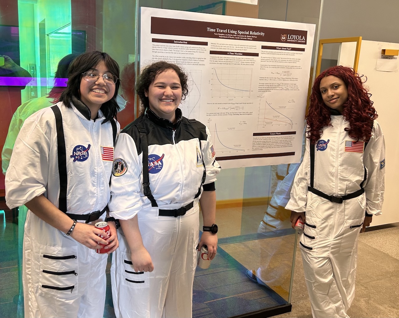 Physics students standing by their poster.