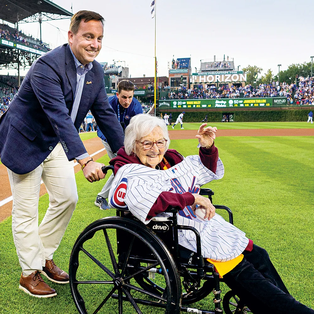 Sister Jean, sitting in a wheelchair, is pushed by President Reed onto the Wrigley Field infield during a recognition break in the game.
