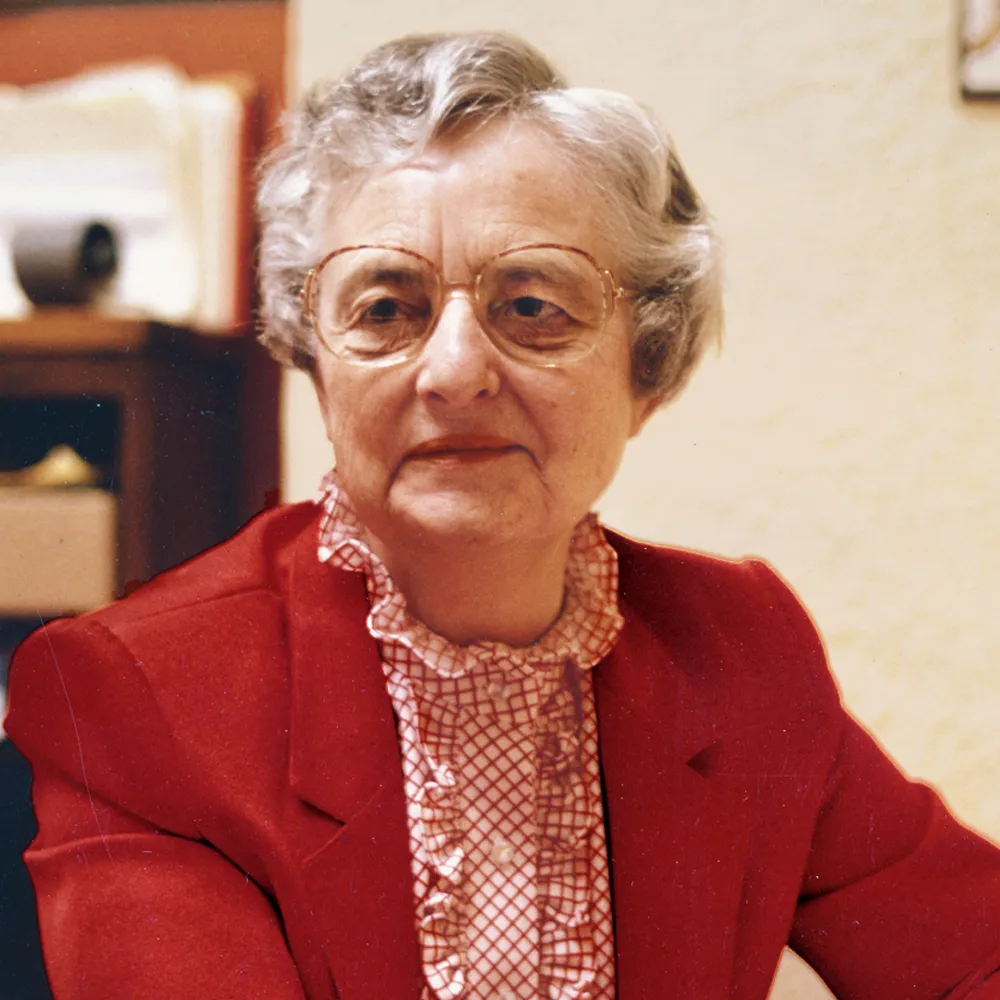 Sister Jean sits wearing a red blazer and a trimmed, ruffled, red and white blouse.