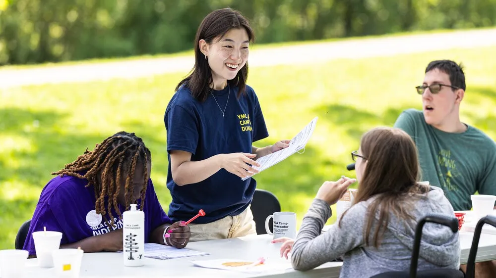 Esther Yun, a research assistant at Loyola's CHATS lab, guides participants through an intervention at Camp Independence