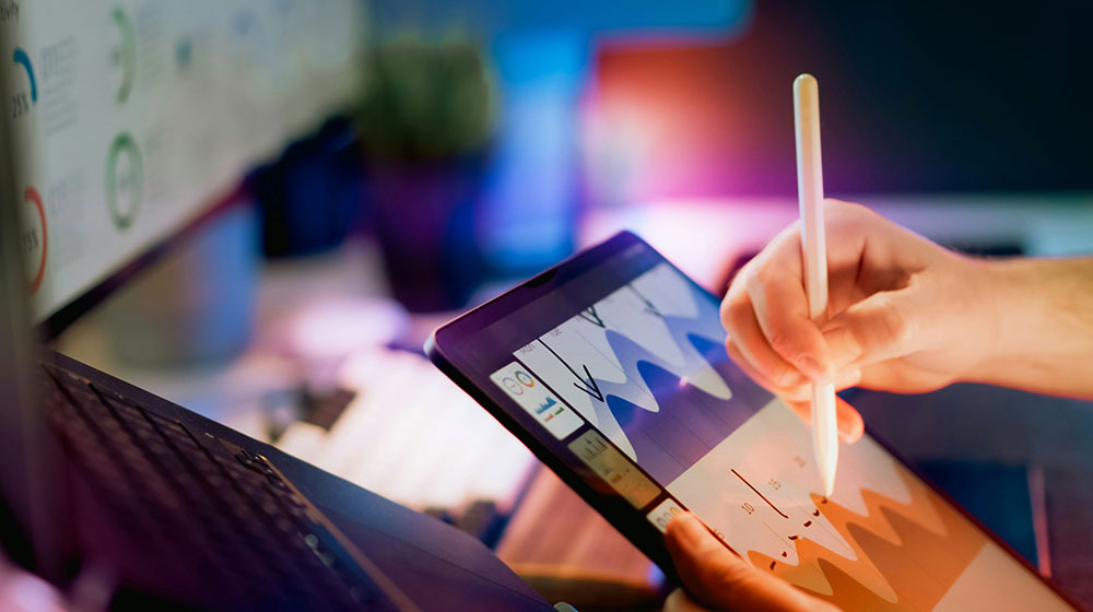 Person using stylus on tablet with charts Person using stylus on tablet with charts