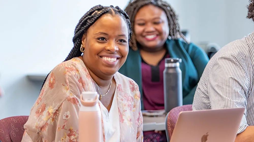Female Scholar sitting in a classroom smiling Female Scholar sitting in a classroom smiling