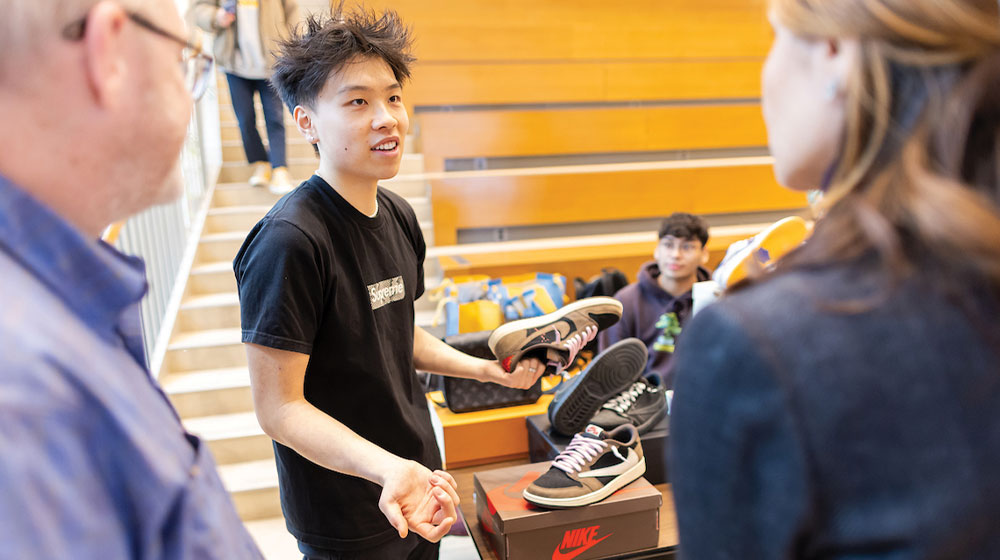 معرض المشاريع الجانبية مع طالب يقدم فكرته لزوج من الأشخاص