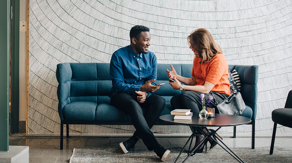 Woman coaching a man while sitting together on sofa