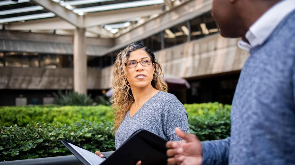 Man and woman walking and talking together on campus