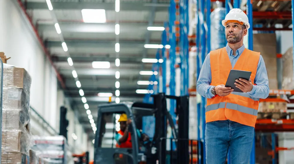 Man in warehouse using tablet screen