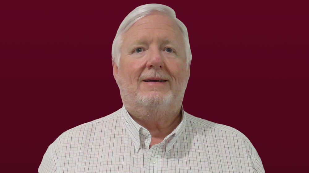 Bob Buddig headshot against maroon backdrop